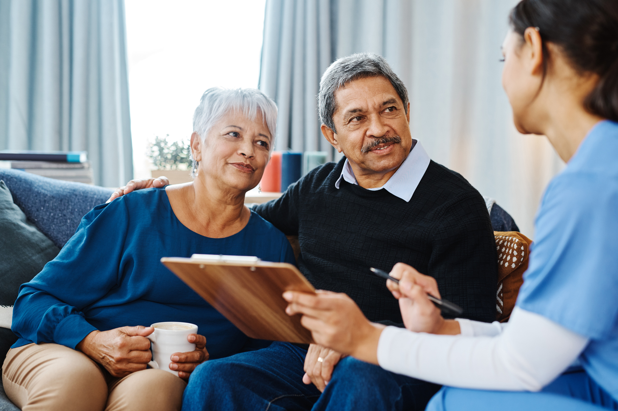 Cheerful elderly couple speaking with a Soleo Health nurse about home infusion therapy